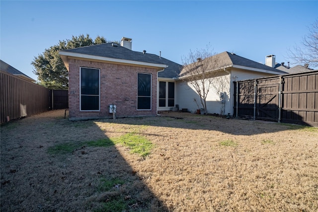 rear view of property with a lawn