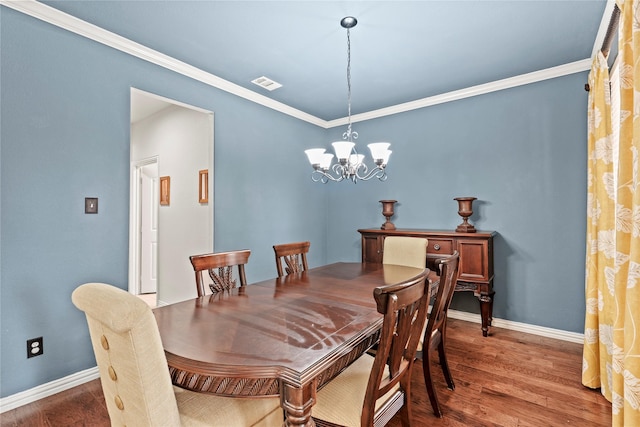 dining room with a notable chandelier, crown molding, and dark hardwood / wood-style floors