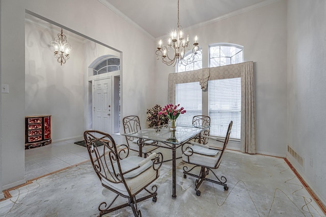 dining area with a towering ceiling, ornamental molding, and a chandelier