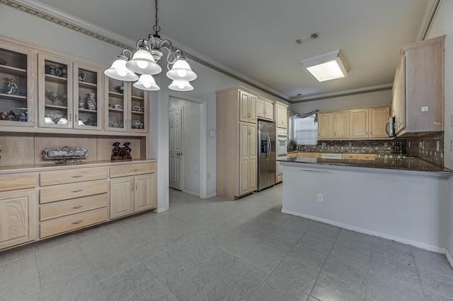 kitchen featuring tasteful backsplash, decorative light fixtures, light brown cabinets, and appliances with stainless steel finishes