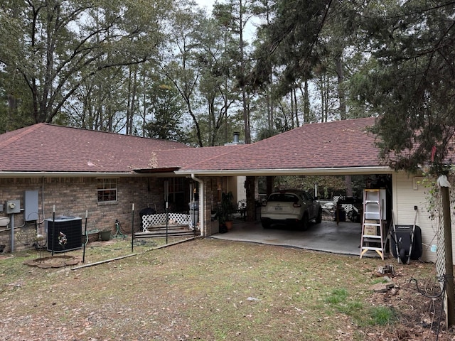 view of front of home featuring cooling unit, a front lawn, and a carport