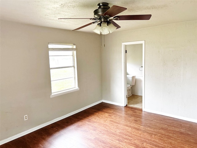 spare room featuring dark wood-type flooring and ceiling fan