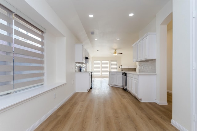 kitchen with white cabinetry, stainless steel dishwasher, sink, and backsplash