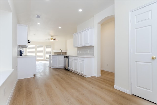 kitchen featuring tasteful backsplash, white cabinetry, sink, kitchen peninsula, and light wood-type flooring