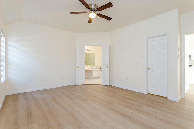 unfurnished bedroom with ceiling fan, lofted ceiling, connected bathroom, and light wood-type flooring