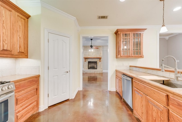 kitchen featuring sink, pendant lighting, stainless steel appliances, a fireplace, and decorative backsplash