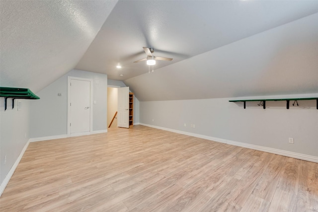 bonus room featuring ceiling fan, vaulted ceiling, a textured ceiling, and light wood-type flooring