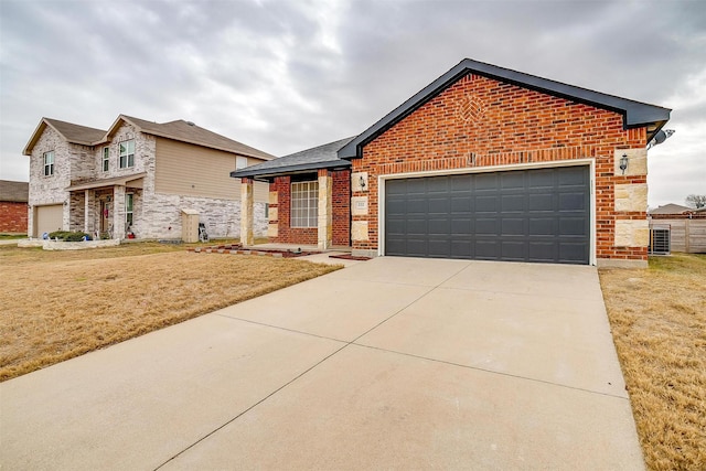 view of front of home featuring a garage, a front yard, and central air condition unit