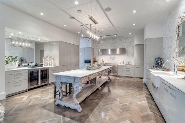 kitchen featuring beverage cooler, gray cabinets, decorative backsplash, and decorative light fixtures