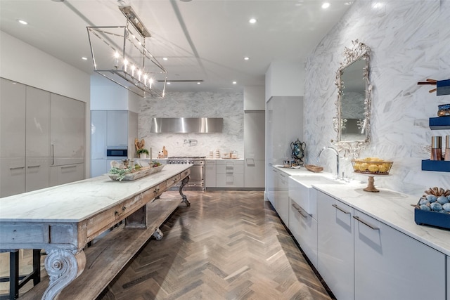 kitchen with light stone counters, stainless steel stove, gray cabinets, and dark parquet floors