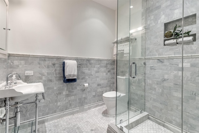 bathroom with tile walls, tile patterned floors, toilet, and walk in shower