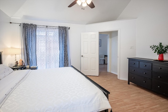 bedroom with ceiling fan, vaulted ceiling, and light wood-type flooring