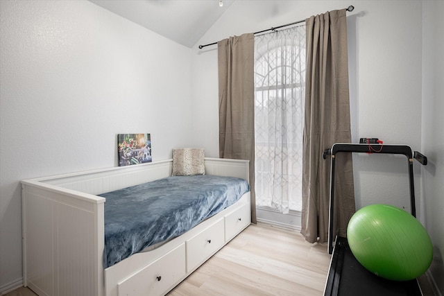 bedroom with lofted ceiling and light hardwood / wood-style flooring