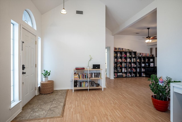 foyer entrance with wood-type flooring, plenty of natural light, ceiling fan, and high vaulted ceiling