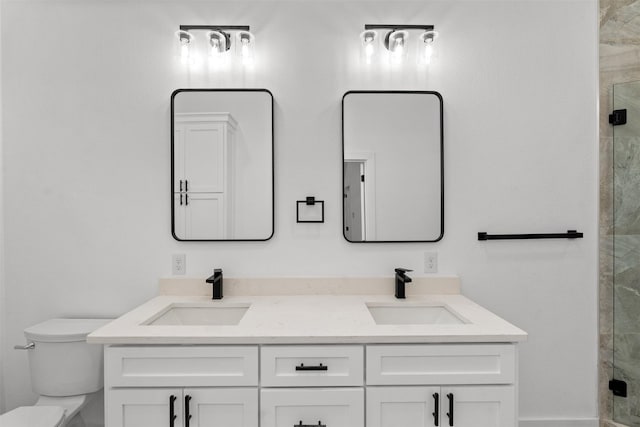 bathroom featuring vanity, toilet, and a shower with shower door