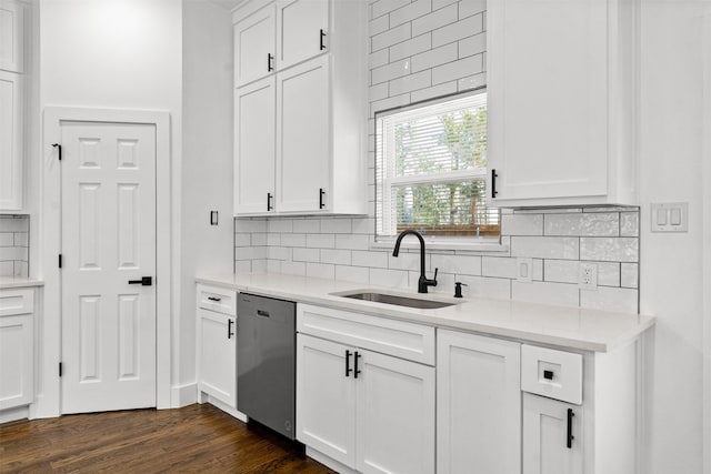 kitchen featuring white cabinetry, sink, backsplash, stainless steel dishwasher, and dark wood-type flooring