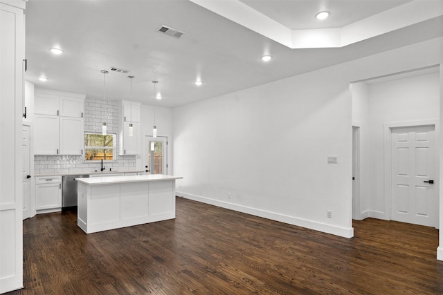 kitchen with white cabinetry, decorative light fixtures, dishwasher, and a kitchen island