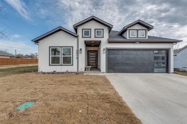 view of front of house with fence, driveway, an attached garage, and stucco siding