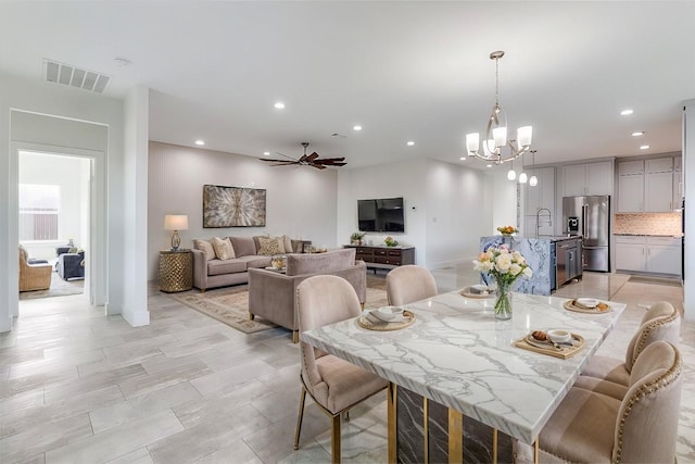 dining space with ceiling fan with notable chandelier, visible vents, and recessed lighting