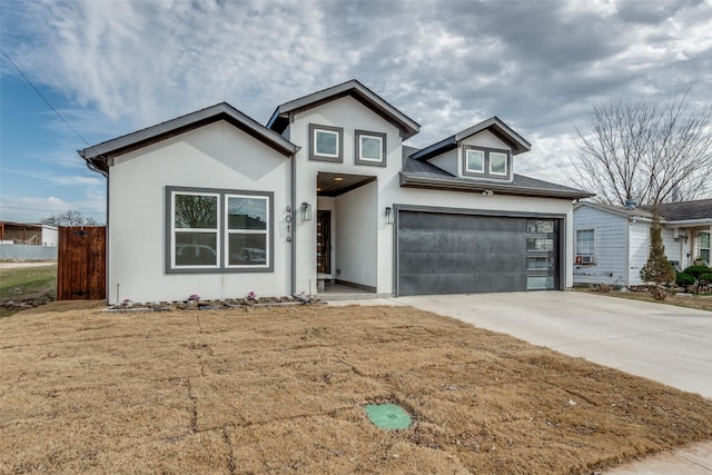 view of front of home with a garage, a front yard, concrete driveway, and stucco siding