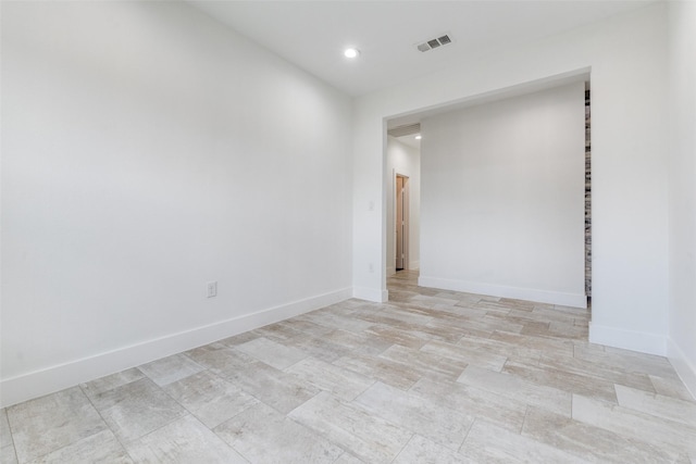 empty room featuring baseboards, visible vents, and recessed lighting