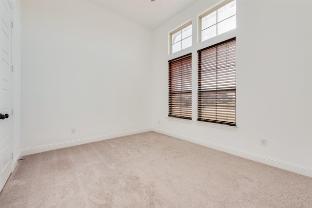 carpeted spare room featuring lofted ceiling