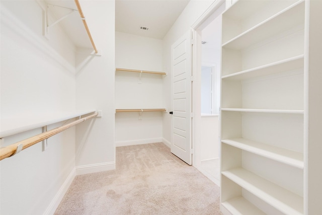 walk in closet featuring light carpet