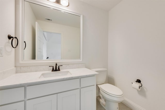 bathroom featuring tile patterned flooring, vanity, and toilet