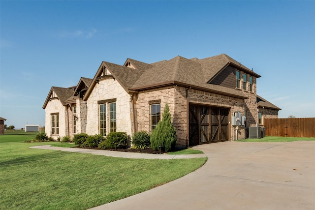 view of front facade featuring a garage, central AC unit, and a front lawn