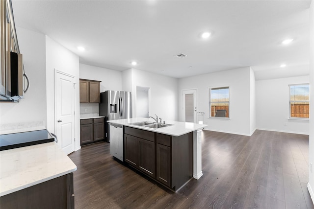 kitchen with stainless steel appliances, dark hardwood / wood-style flooring, sink, and a center island with sink