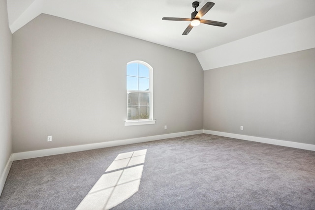 spare room with ceiling fan, lofted ceiling, and carpet flooring