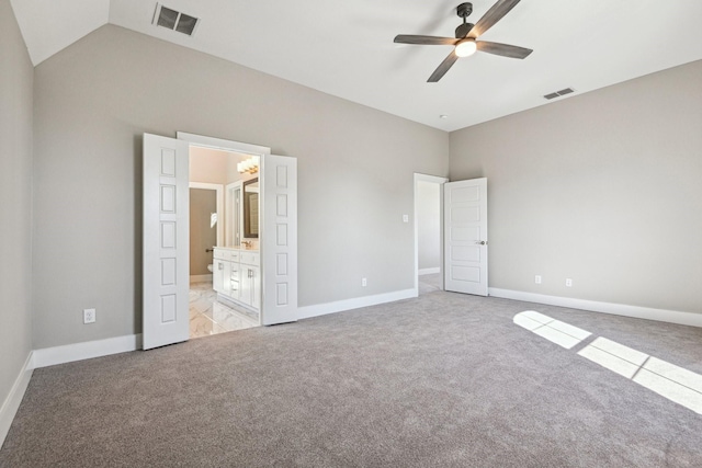 unfurnished bedroom featuring lofted ceiling, light colored carpet, ceiling fan, and ensuite bathroom