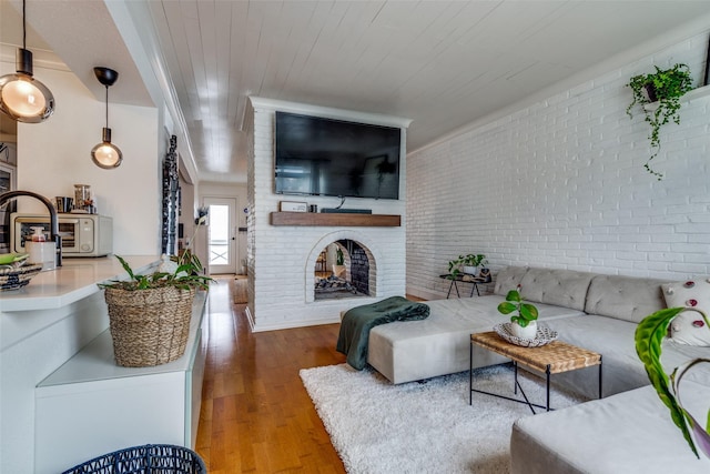 living room featuring brick wall, a fireplace, hardwood / wood-style floors, and wooden ceiling