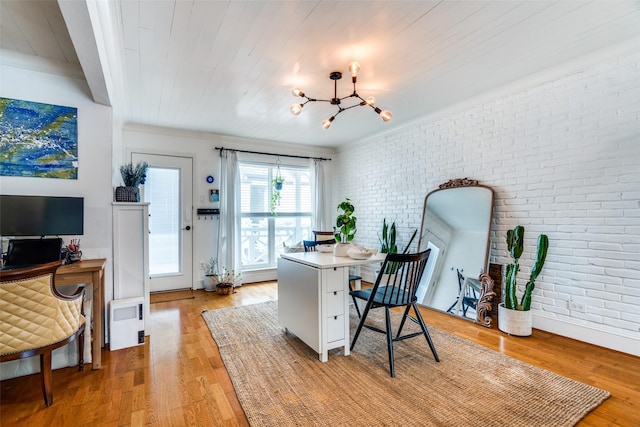 office with light hardwood / wood-style flooring, wooden ceiling, a chandelier, and brick wall