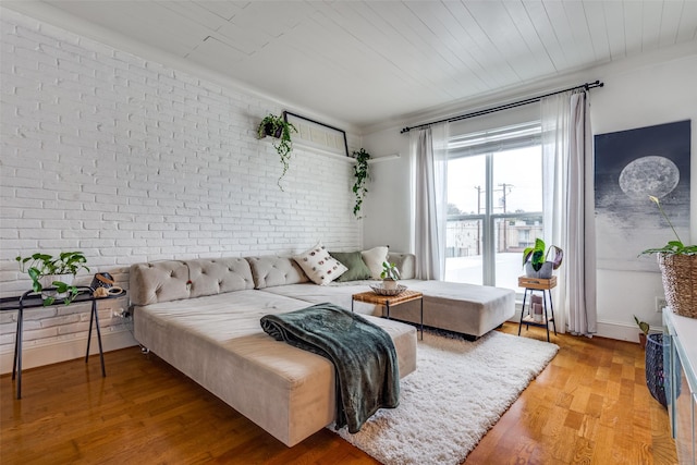 bedroom featuring brick wall and hardwood / wood-style floors