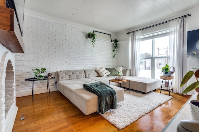 living room with brick wall and light wood-type flooring