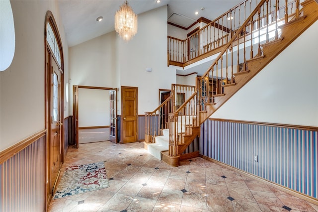 tiled foyer entrance featuring a high ceiling and a notable chandelier