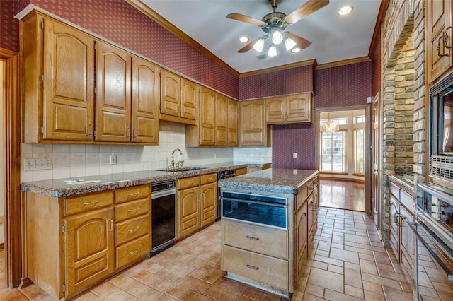 kitchen featuring sink, ceiling fan, a center island, ornamental molding, and dark stone counters