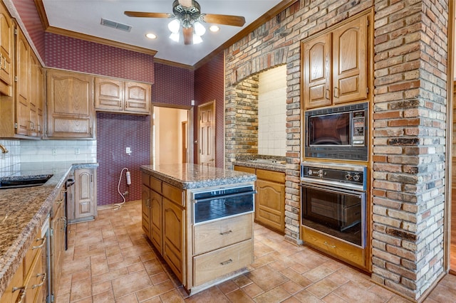 kitchen with a center island, light stone countertops, sink, and oven