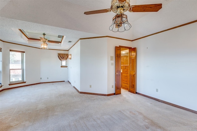 unfurnished room with ceiling fan, a tray ceiling, crown molding, light carpet, and a textured ceiling