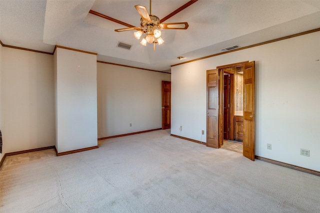 spare room with ceiling fan, ornamental molding, light colored carpet, and a textured ceiling