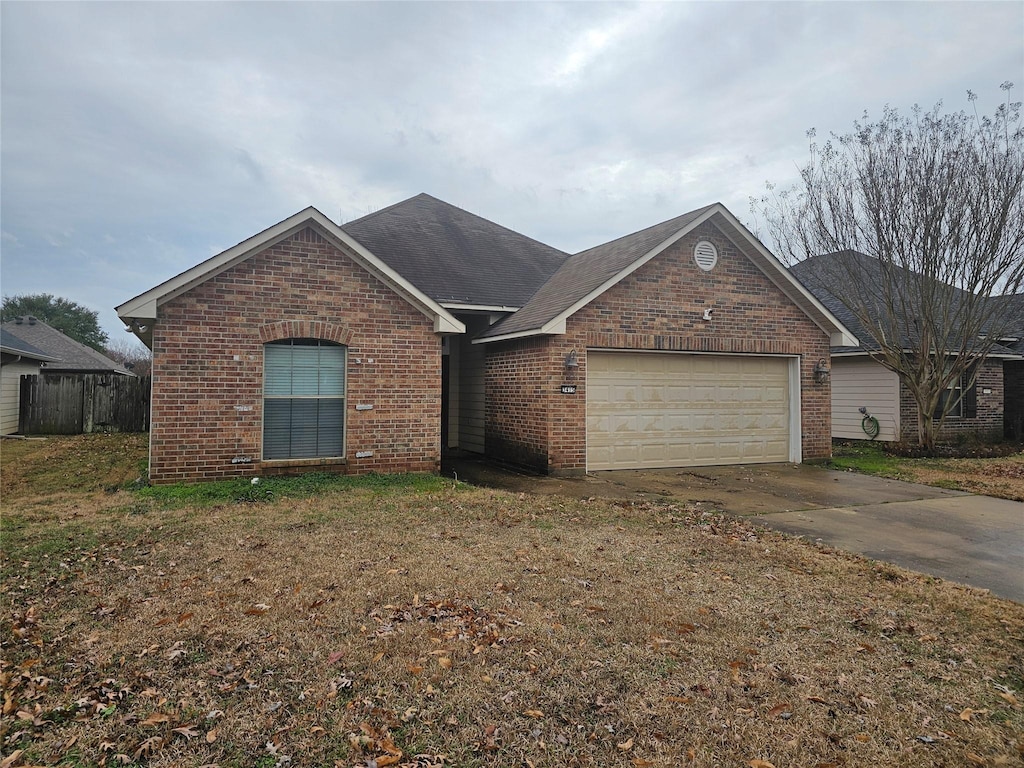 ranch-style home with a garage and a front yard