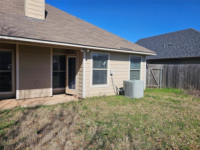 rear view of property featuring a yard and central AC unit