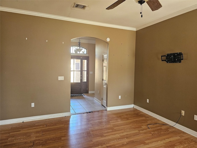 empty room with ornamental molding, light hardwood / wood-style floors, and ceiling fan