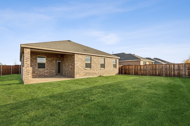 back of property featuring a yard and a patio