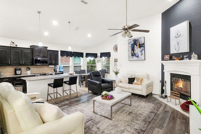 living room featuring ceiling fan, dark hardwood / wood-style flooring, and high vaulted ceiling