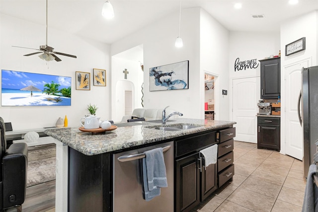 kitchen with sink, hanging light fixtures, a kitchen island with sink, stainless steel dishwasher, and light stone countertops