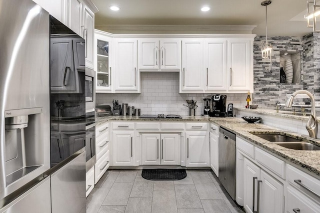 kitchen featuring stainless steel appliances, hanging light fixtures, sink, and white cabinets