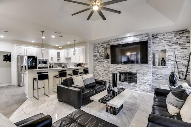 living room featuring ceiling fan, a large fireplace, and sink