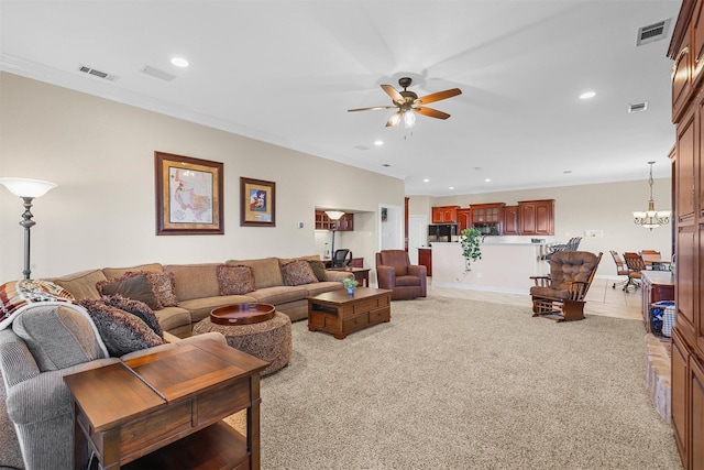 carpeted living room featuring ornamental molding and ceiling fan with notable chandelier